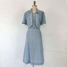 DETAILS : Up for your consideration is this rare XXL volup 1950's day dress with matching belt and jacket. It is a lightweight cotton material with a blue and white gingham print. There are three sections of floral daisy appliques at the neckline and pockets at the hips. This dress has been laundered, steamed, and is ready to wear! FABRIC : Cotton COLOR : Cornflower Blue and White FASTENERS : Metal Side Zip, Belt DESIGNER : House of Shroyer's CONDITION : Excellent condition. One additional hole has been punched into the belt - see photos. Please note that some wear is expected with all vintage. SIZING : fits like modern size XXL. Dress has been pinned to dress form. Measurements (inches) :    bust: 46 waist: 38 hips: 48 length: 46 bodice: 17.5 **Please review photos carefully and ask any q 50s House, Designer House, Dress With Jacket, Blue And White Gingham, Plus Size Vintage, Gingham Print, Dress Form, Cornflower Blue, Day Dress