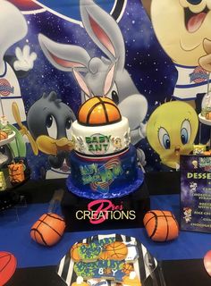 a birthday cake with an image of bugs and other cartoon characters on the wall behind it