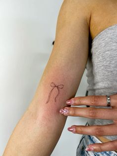 a woman's arm with a small tattoo on it