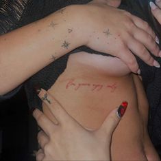 two women with tattoos on their backs holding each other