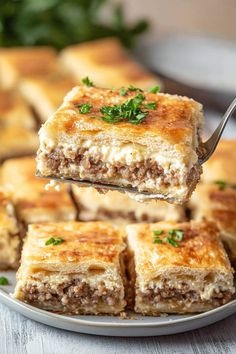 a piece of meat and cheese bake being lifted from a plate with a fork