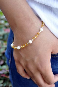 Abundance Pearls and Yellow Crystals Bracelet is an empowering accessory that infuses your everyday life with love and abundance. Pearls usher in Love, Beauty, and Wealth, while Yellow Crystals attract wealth, abundance, and growth. Oxidized sterling silver beads and spacers add an elegant touch to this beautiful balancing and healing bracelet. Create a stylish layered look by pairing it with a bangle or other layering bracelets. Pearls: Love, Beauty, Wealth Yellow Crystal: Radiance - Happiness Elegant Gold Crystal Bracelet For Meditation, Elegant Hand-strung Amber Bracelets, Elegant Hand-strung Amber Bracelet, Spiritual Citrine Bracelet As A Gift, Bracelets Pearls, Layering Bracelets, Yellow Crystals, Wealth Abundance, Himalayan Quartz