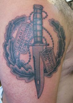 a man with a tattoo on his shoulder has a knife and chain attached to it