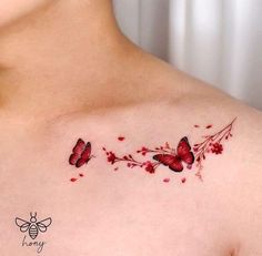 a woman's chest with two butterflies on it and flowers in the middle of her chest