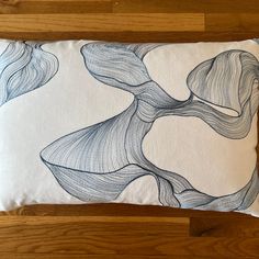 a blue and white pillow sitting on top of a wooden floor