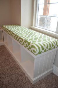 a window seat with a green and white cover