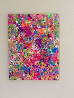 an abstract painting on a white wall with multicolored paint splattered all over it