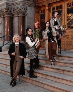 four women standing on steps in front of a building