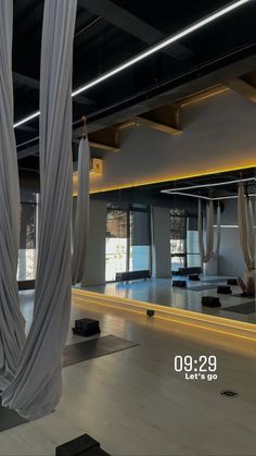 an empty yoga studio with white drapes hanging from the ceiling