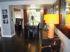 a living room filled with furniture and a lamp on top of a hard wood floor