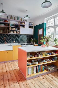 a kitchen with wooden floors and green walls, white counter tops and yellow cabinets is shown