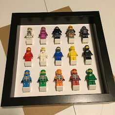 lego minifigures are arranged in a shadow box on the floor, ready to be displayed