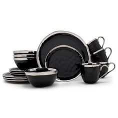 black and silver dinnerware set with matching saucers, cups and spoons on white background