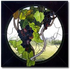 a round stained glass window with grapes on it