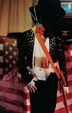 a man in a suit and top hat with an american flag on the back ground