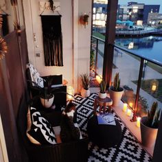 a living room filled with lots of furniture next to a window covered in candles and potted plants