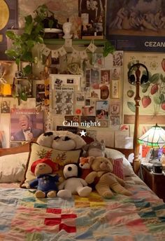 a bed with stuffed animals on it in a bedroom next to a lamp and pictures