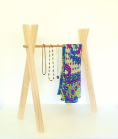 two wooden clothes racks with necklaces hanging from them