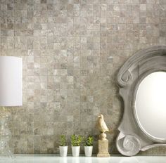 a mirror and some vases on a shelf in front of a wall with tile