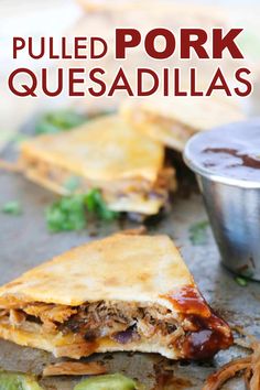 pulled pork quesadillas on a plate with a cup of salsa and sauce