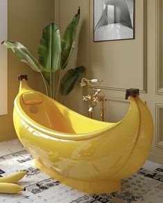 a large banana shaped bathtub sitting on top of a floor next to a plant