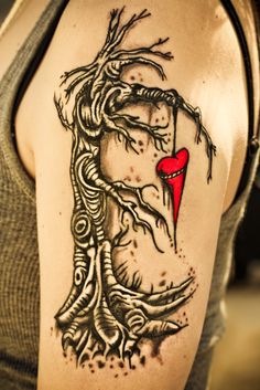 a woman's arm with a tattoo on it and a red heart in the middle