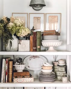 the shelves are filled with dishes and vases, books, and pictures on them