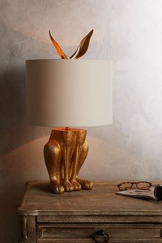 a lamp that is sitting on top of a table next to a dresser and mirror