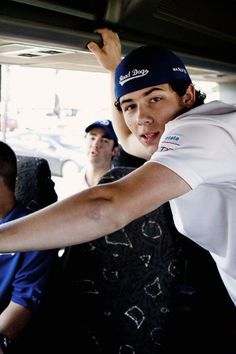 a group of young men riding on the back of a bus next to each other