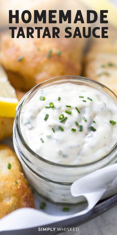 homemade tartar sauce in a small glass jar with lemon wedges on the side