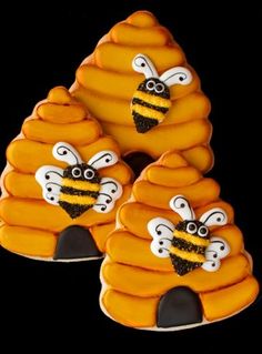 three decorated cookies in the shape of bees