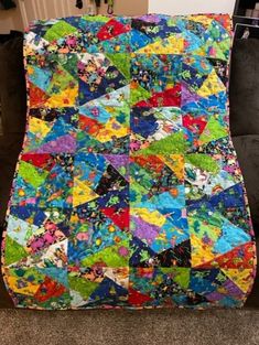 a colorful quilt is on the floor next to a couch