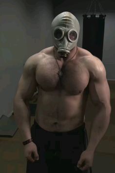 a shirtless man wearing a gas mask