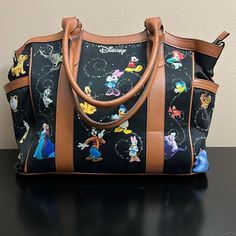 New Condition Disney Collectors Bag With Tinkerbell Charm.. Full Zip Across Top And 4 Feet On Bottom This Bag Is Large Enough To Be A Weekender Or Diaper Bag But Easy Lightweight To Carry While Out It Has All The Main Disney Characters From Over The Years And Is In Pristine Condition. Also Has Double Rolled Handles Loads Of Room Inside And Even A Center Zip Area As Well Brown Disney Bags For Everyday Use, Disney Style Brown Bag For Everyday Use, Disney Everyday Brown Bags, Disney Style Travel Shoulder Satchel Bag, Disney Style Shoulder Bag For Travel, Disney Shoulder Bag With Removable Pouch For Travel, Disney Travel Bag With Removable Pouch, Disney Brown Travel Bags, Disney Style Brown Travel Bag