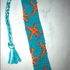 a blue and orange crocheted tie with an orange starfish design on it