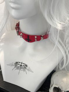 This red choker features a decorative inverted cross pendant adorned with studs. Add a touch of edgy style to your look with this statement piece. Perfect for adding a bold and unique touch to any outfit, this choker is a must-have accessory for those who love to stand out. Made with high-quality materials, it is both durable and eye-catching. Ideal for those who love to express their individuality through fashion.  The price is for a choker only, others are not included. Grunge Choker For Cosplay, Trendy Choker For Halloween And Alternative Fashion, Emo Choker For Alternative Fashion, Red Punk Choker For Festivals, Punk Choker For Halloween Festival, Edgy Choker For Halloween Festival, Punk Halloween Festival Choker, Edgy Halloween Festival Choker, Red Emo Choker Jewelry