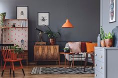 an image of a living room setting with grey walls and orange accents on the furniture