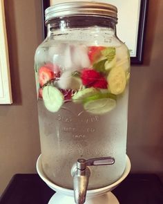 a mason jar filled with water and fresh cut up veggies on top of a scale