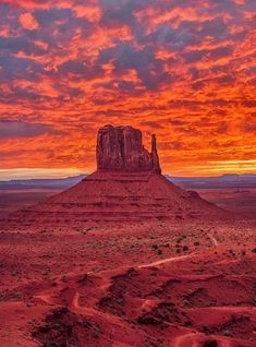 the sun is setting over monument rock in monument national park, utah with an orange and pink sky