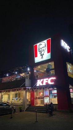 the front of a kfc restaurant lit up at night