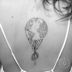 the back of a woman's shoulder with a world map tattoo on it