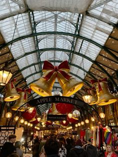 the inside of an apple market with lots of lights and bells hanging from it's ceiling