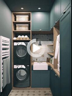 a washer and dryer in a small room with blue walls, white tile flooring and green cabinets