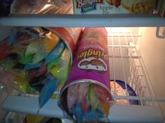 an open refrigerator filled with lots of food and condiments in plastic wrap on the bottom shelf