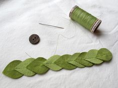 the thread is being sewn together with green leaves