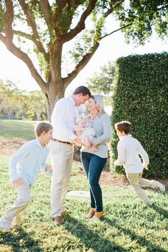 a family is playing in the grass together