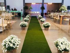 a long green aisle with white flowers and greenery