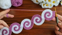 two hands are crocheting the letters c and o on a string with yarn