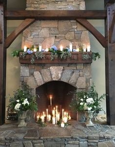 the fireplace is decorated with candles and flowers