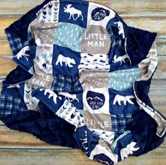 a blue and white quilted blanket on top of a wooden floor with the words little man printed on it